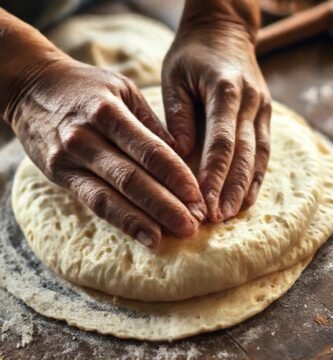 Manos trabajan masa tradicionalmente con luz cálida